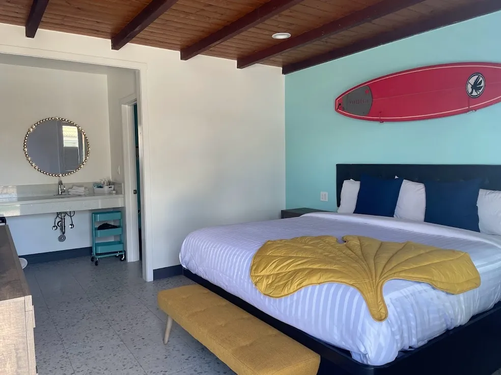 Deluxe room with a red surfboard above the bed